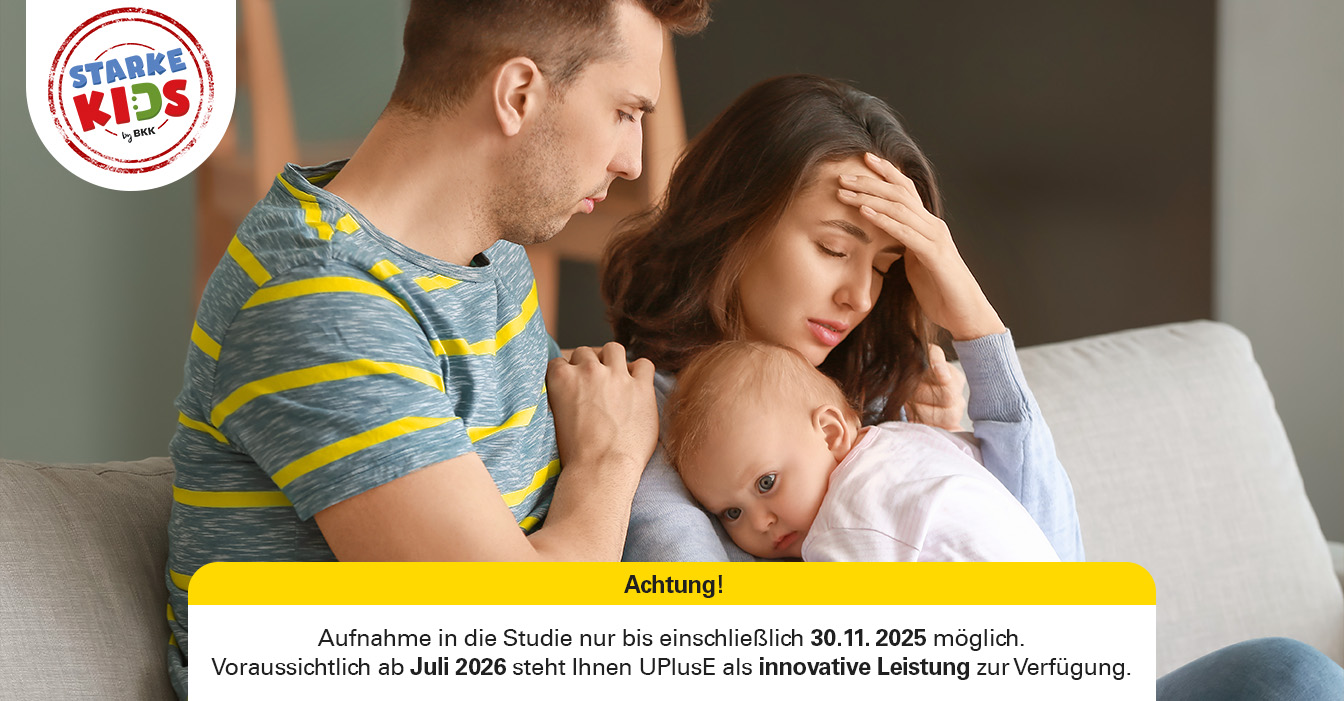 Besorgter Mann umarmt Frau, die Kopfschmerzen zu haben scheint, während sie ein kleines Kind hält, das auf ihrer Schulter ruht.