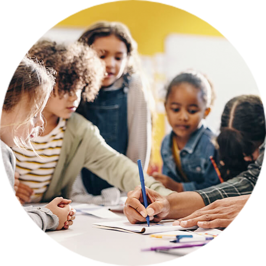 Ein Lehrer hilft einer Gruppe konzentrierter Kinder beim Lernen in einem lebendigen Klassenzimmer.